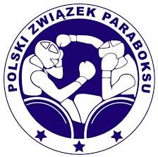 Logo Polskiego Związku Paraboksu. Okrągły, biało-niebieski emblemat przedstawiający dwóch bokserów na wózkach inwalidzkich, wymieniających ciosy.